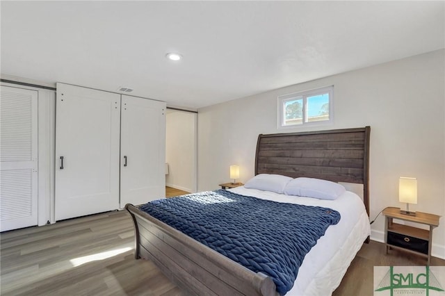 bedroom with hardwood / wood-style flooring and multiple closets