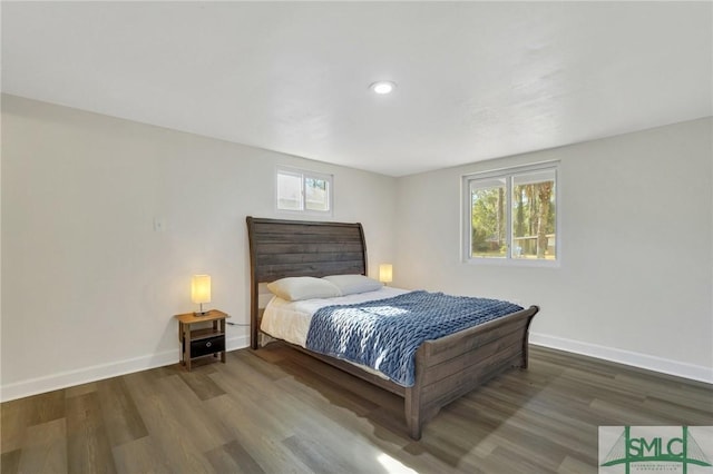 bedroom featuring multiple windows and dark hardwood / wood-style flooring