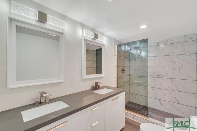 bathroom featuring a tile shower, vanity, and toilet