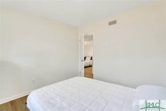 bedroom with dark wood-type flooring