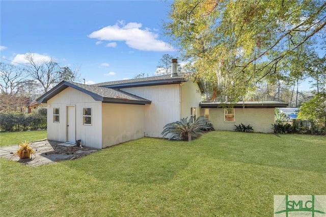 rear view of property with a lawn