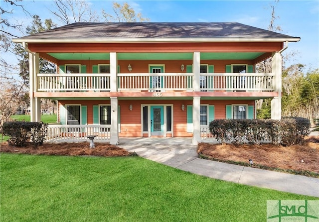 view of front facade with a balcony and a front yard