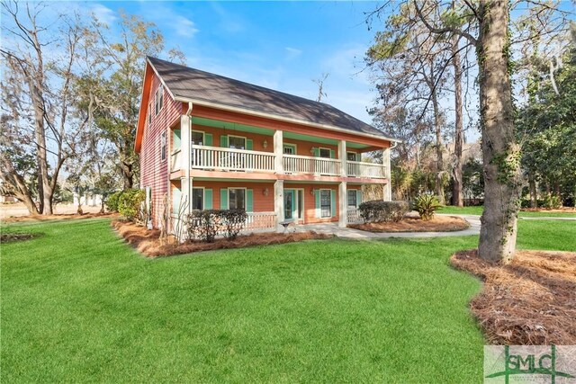 back of house featuring a balcony and a yard