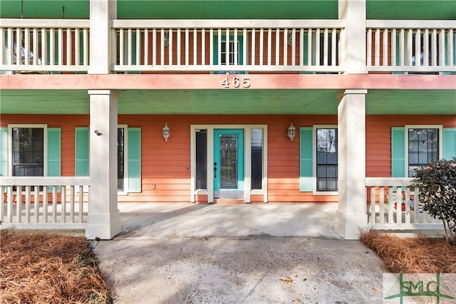 entrance to property featuring a balcony and covered porch