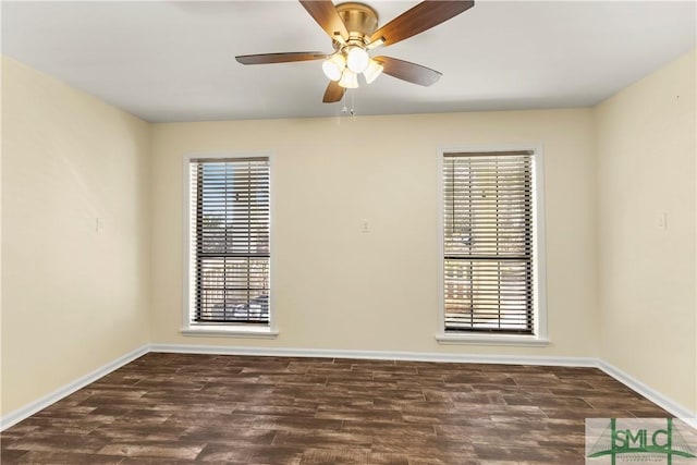 spare room featuring baseboards, dark wood-style flooring, and ceiling fan