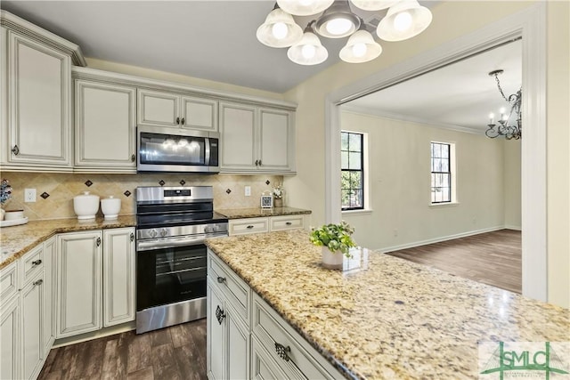 kitchen with ornamental molding, backsplash, dark wood-style floors, appliances with stainless steel finishes, and an inviting chandelier