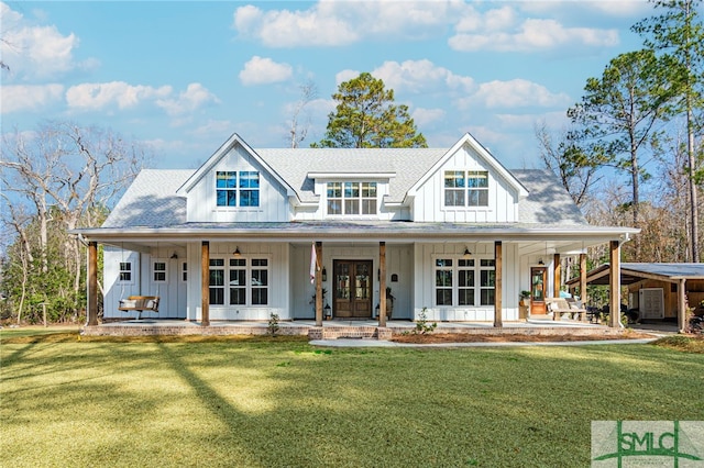 rear view of house with a lawn, french doors, and covered porch