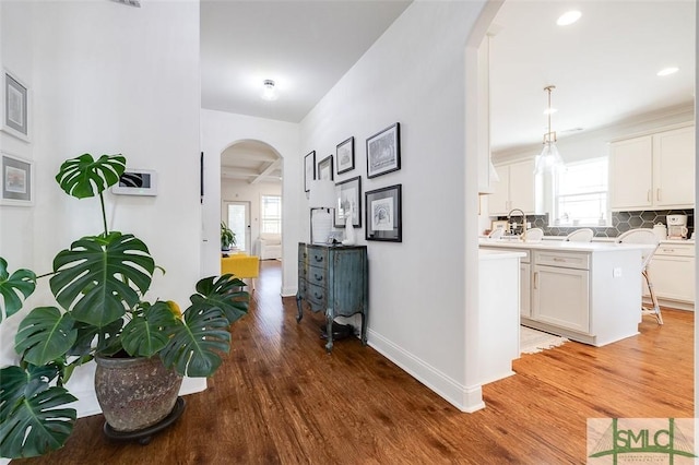 hallway featuring hardwood / wood-style flooring and sink