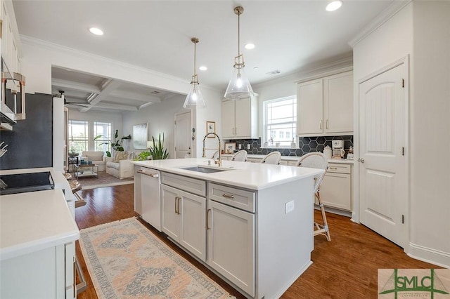 kitchen featuring pendant lighting, sink, dishwasher, white cabinetry, and an island with sink