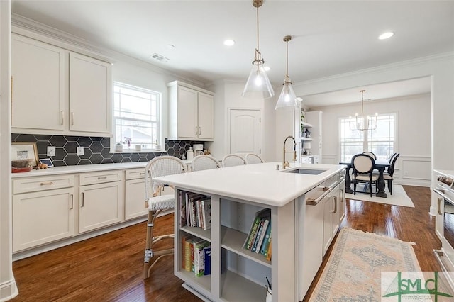 kitchen with sink, white cabinetry, a healthy amount of sunlight, a center island with sink, and decorative light fixtures