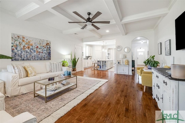 living room featuring hardwood / wood-style floors, beamed ceiling, ornamental molding, coffered ceiling, and ceiling fan