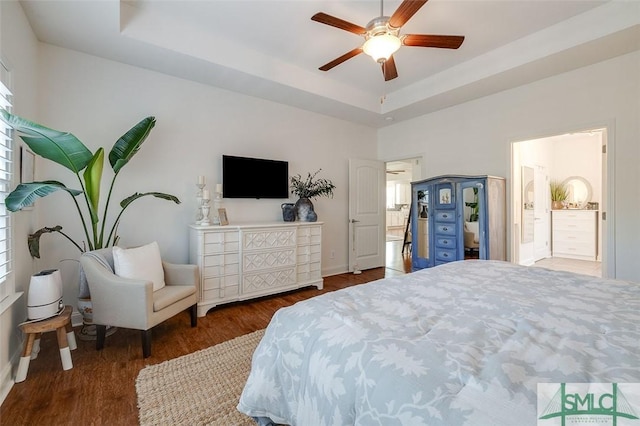 bedroom with ceiling fan, dark hardwood / wood-style flooring, and a raised ceiling