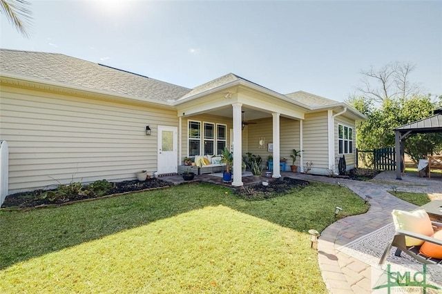 back of property with a gazebo and a yard