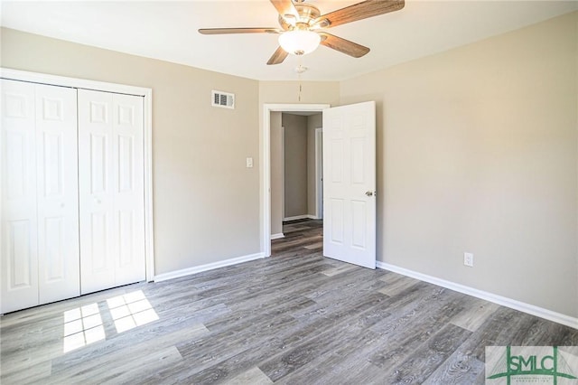 unfurnished bedroom featuring wood-type flooring, a closet, and ceiling fan