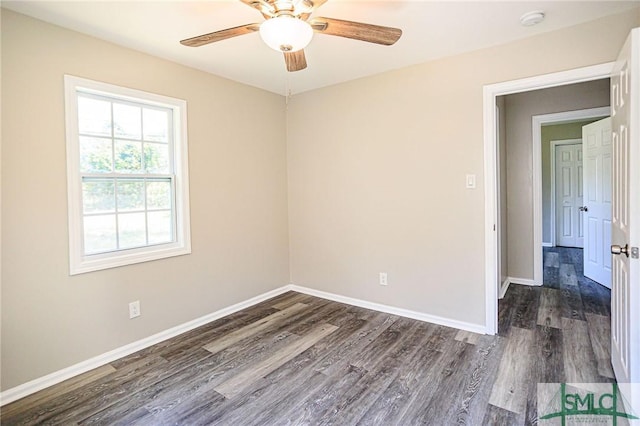 spare room with dark wood-type flooring and ceiling fan