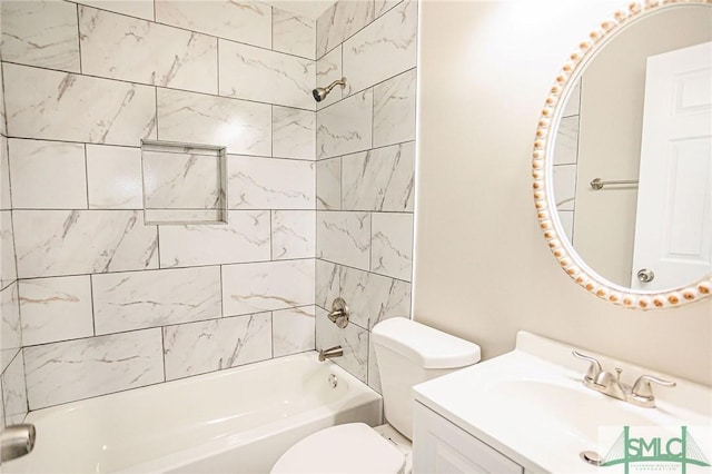 full bathroom featuring vanity, tiled shower / bath combo, and toilet