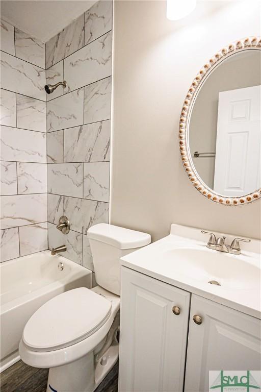 full bathroom with hardwood / wood-style flooring, vanity, toilet, and tiled shower / bath combo