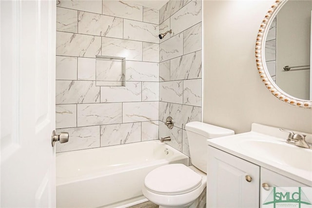 full bathroom with tiled shower / bath, vanity, and toilet