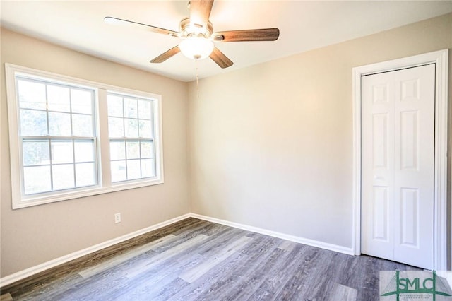 spare room with dark wood-type flooring and ceiling fan