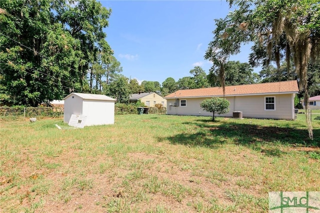 view of yard featuring central AC and a storage unit