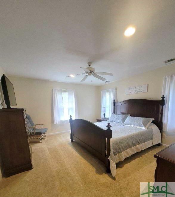 bedroom with ceiling fan and light colored carpet