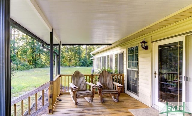 deck featuring a porch and a lawn