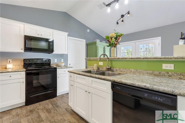 kitchen featuring white cabinetry, vaulted ceiling, sink, and black appliances