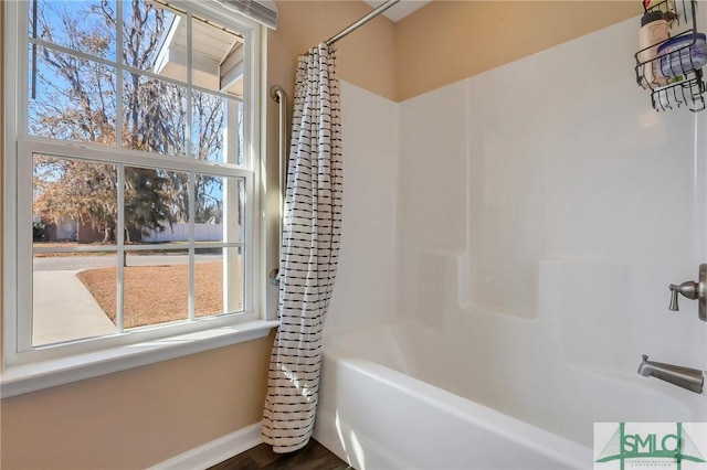 bathroom featuring a healthy amount of sunlight and shower / bathtub combination with curtain