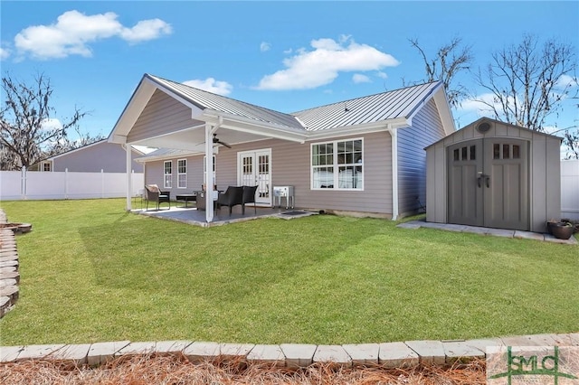 back of property featuring a shed, a patio area, french doors, and a lawn