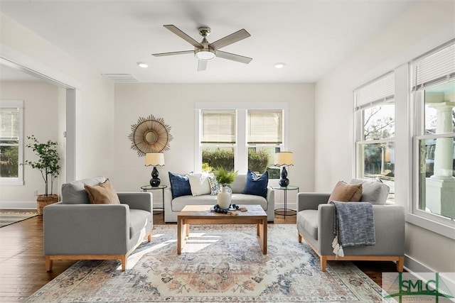 living room featuring a ceiling fan, wood finished floors, baseboards, visible vents, and recessed lighting