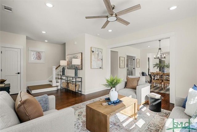 living room with recessed lighting, wood finished floors, visible vents, stairs, and ceiling fan with notable chandelier
