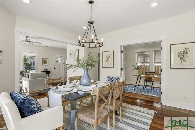 dining space with ceiling fan with notable chandelier, baseboards, wood finished floors, and recessed lighting