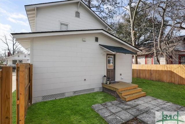 back of property with fence, crawl space, and a yard