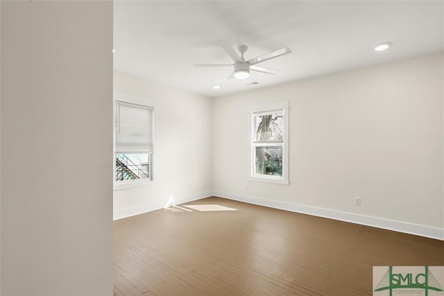 spare room with hardwood / wood-style floors, a wealth of natural light, and ceiling fan