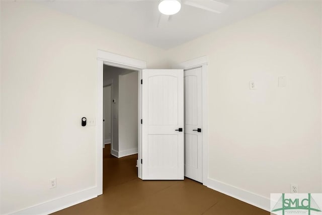 unfurnished bedroom with concrete floors, a closet, baseboards, and ceiling fan