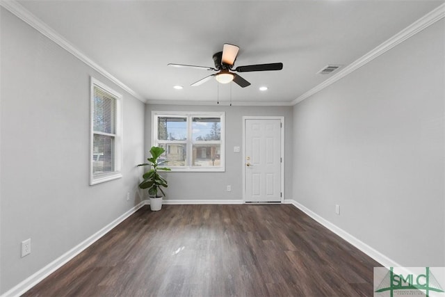 empty room featuring dark wood-type flooring, ceiling fan, and crown molding