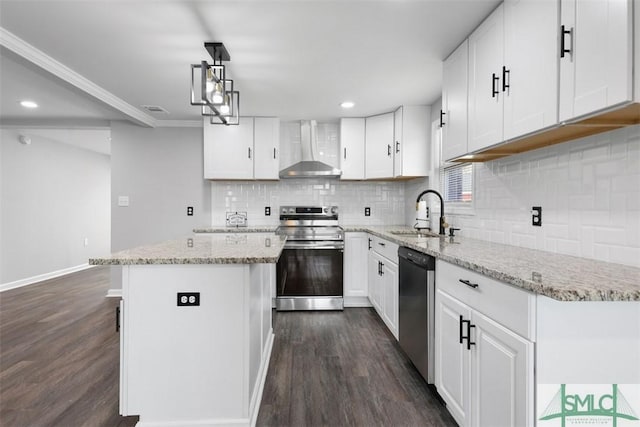 kitchen featuring a kitchen island, appliances with stainless steel finishes, white cabinetry, sink, and wall chimney range hood