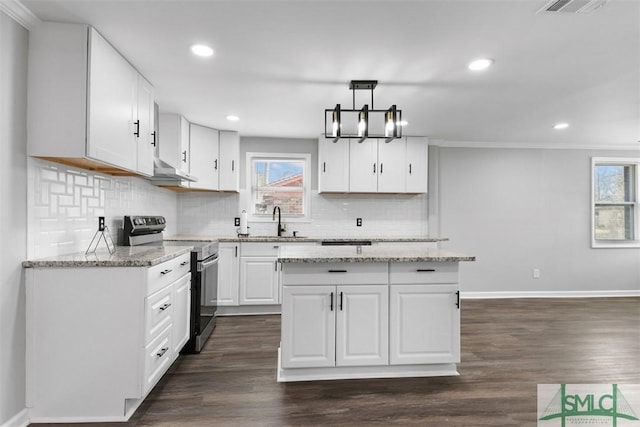 kitchen featuring decorative light fixtures, white cabinetry, sink, a center island, and electric stove