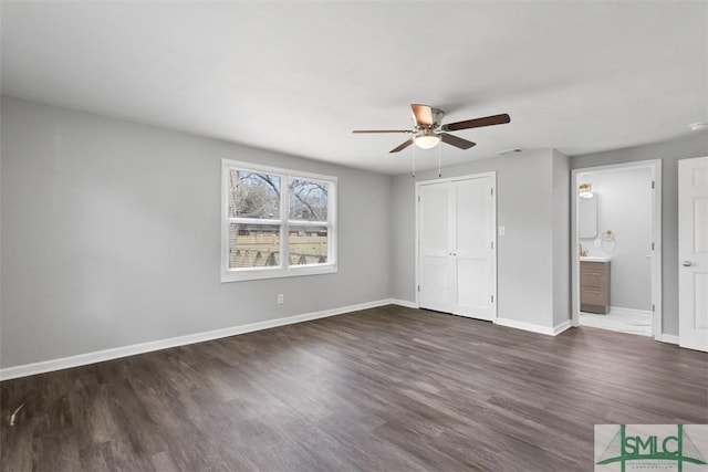 unfurnished bedroom with ceiling fan, connected bathroom, dark hardwood / wood-style flooring, and a closet