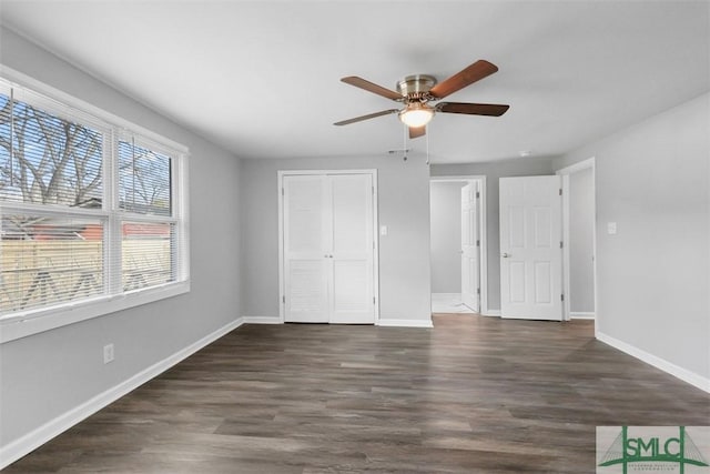 unfurnished bedroom featuring dark wood-type flooring, ceiling fan, and a closet