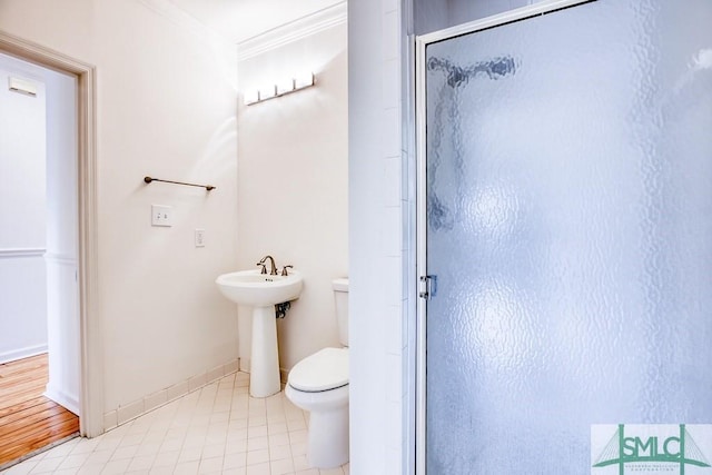 bathroom with walk in shower, toilet, sink, ornamental molding, and tile patterned flooring