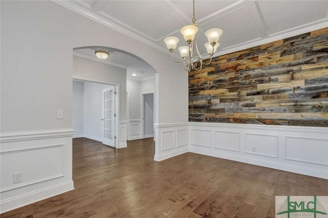 unfurnished dining area featuring dark hardwood / wood-style flooring, a notable chandelier, and crown molding