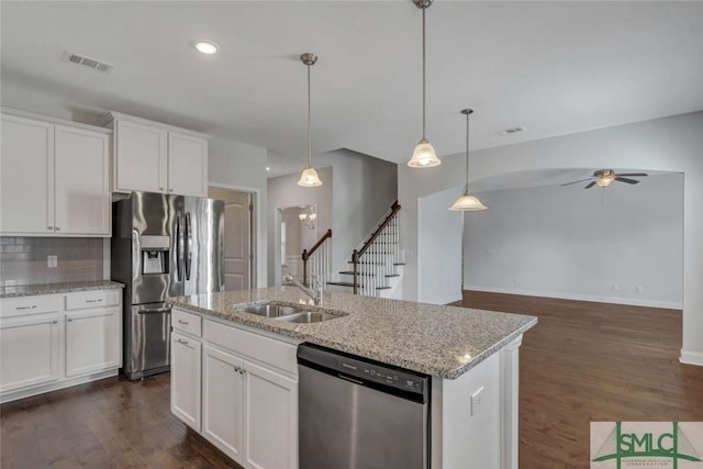 kitchen featuring pendant lighting, white cabinetry, a kitchen island with sink, light stone counters, and stainless steel appliances