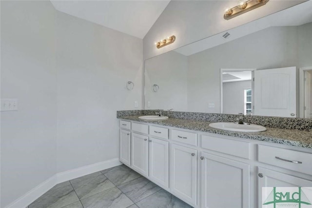 bathroom featuring vanity and lofted ceiling