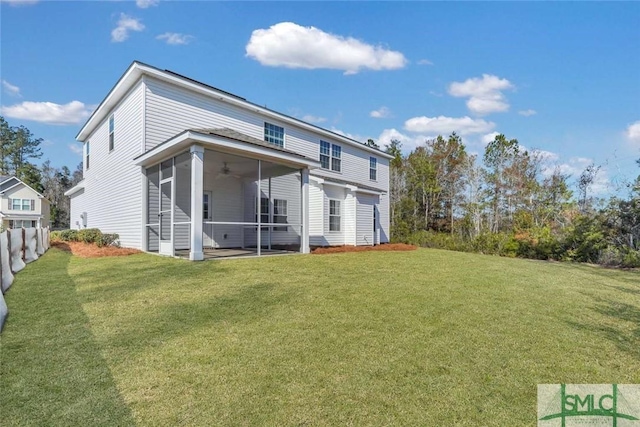 rear view of house with ceiling fan, a sunroom, and a lawn