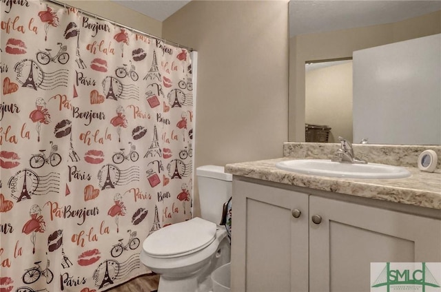 bathroom featuring walk in shower, vanity, and toilet