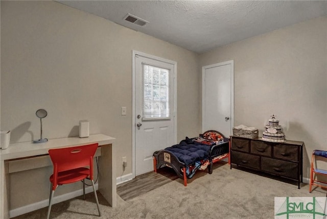 carpeted bedroom featuring a textured ceiling