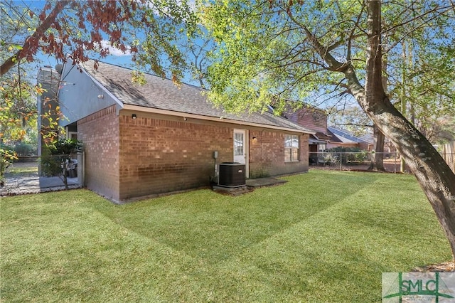 rear view of property featuring a yard and cooling unit