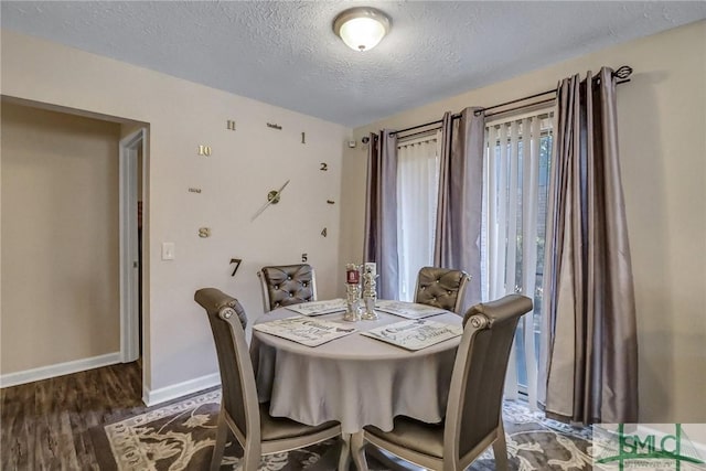 dining area featuring dark hardwood / wood-style floors and a textured ceiling