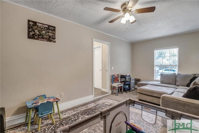 carpeted living room with ceiling fan, ornamental molding, and a textured ceiling